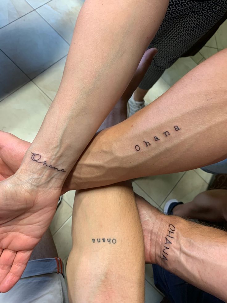 three people holding hands with tattoos on their arms and the words obama written in cursive writing