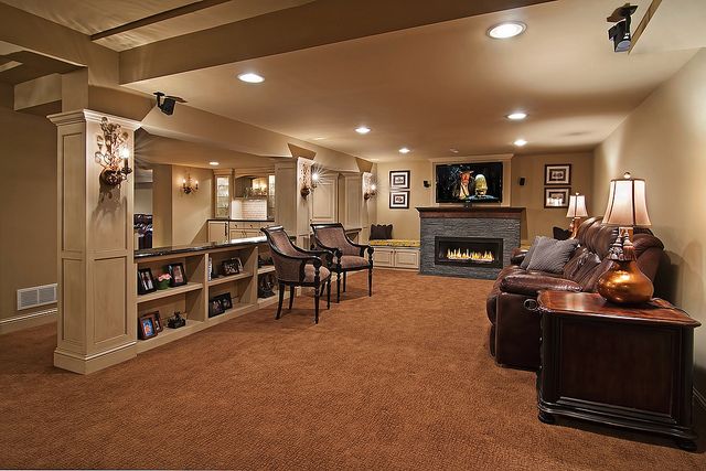 a living room filled with furniture and a fire place in the middle of a room