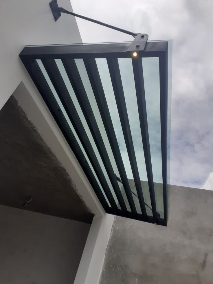 the corner of a building with a light on it's side and an open window