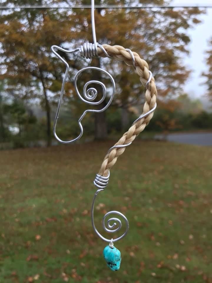 a wind chime hanging from a wire in the grass