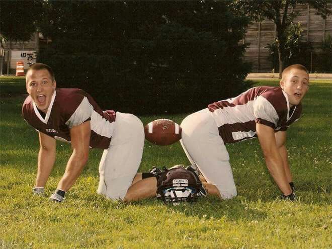 two young men are playing football in the grass