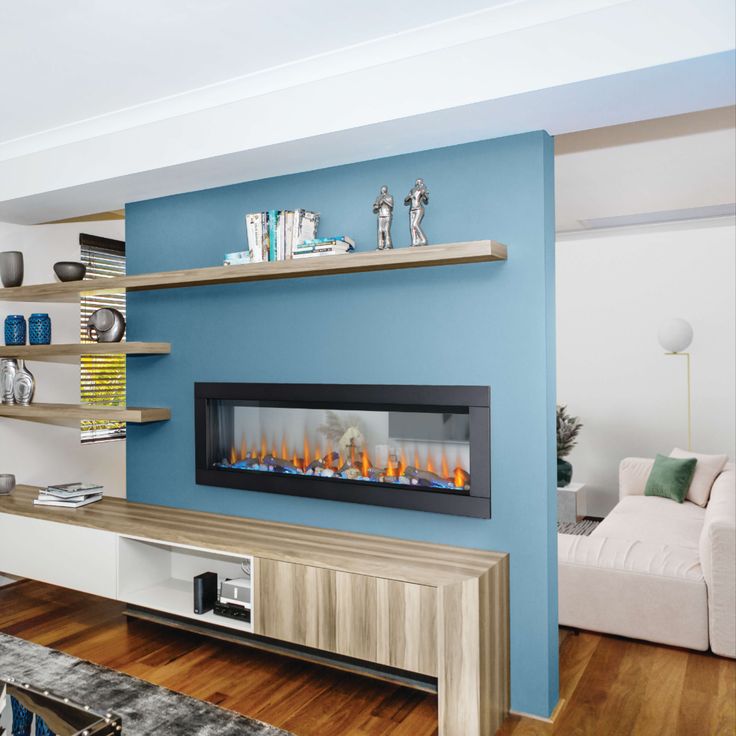 a living room with blue walls and a fireplace in the center, surrounded by shelves