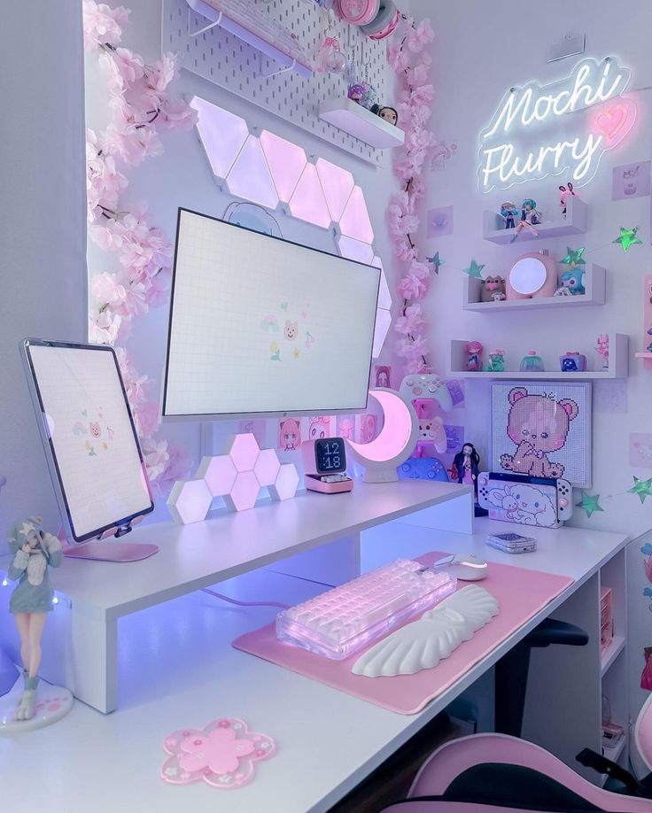 a desk with a computer monitor and keyboard on it in a room that has pink decorations