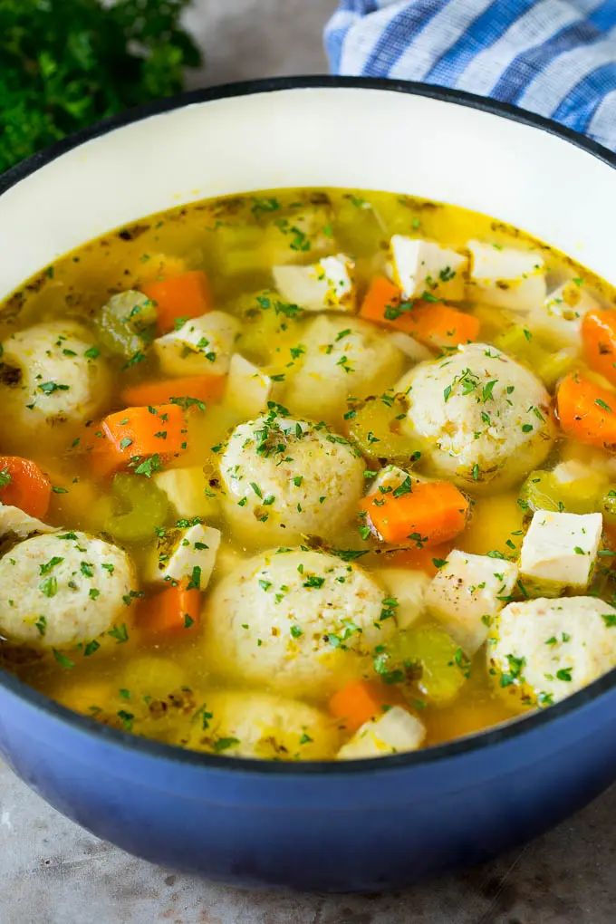 a blue bowl filled with chicken and dumpling soup