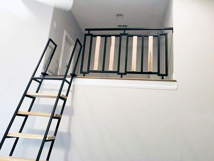 there is a ladder going up to the top of the stairs in this room with white walls