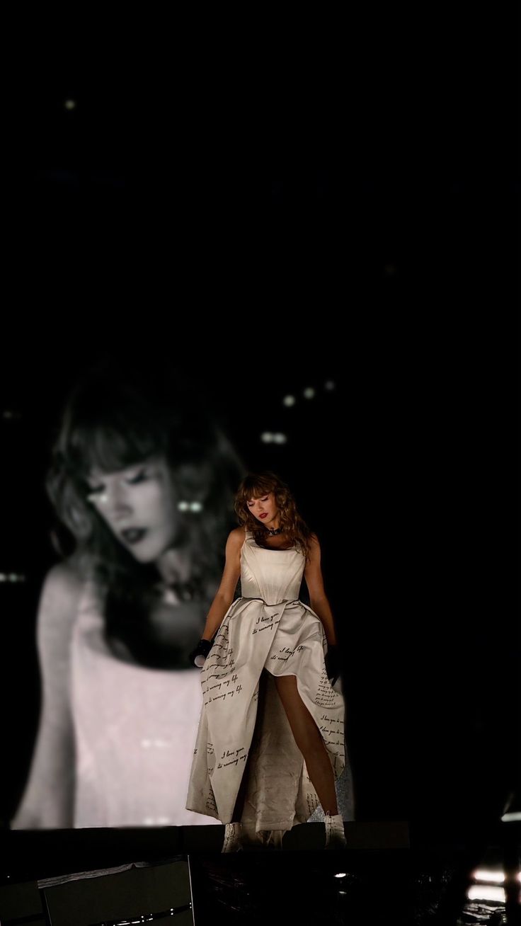 a woman in white dress standing on stage