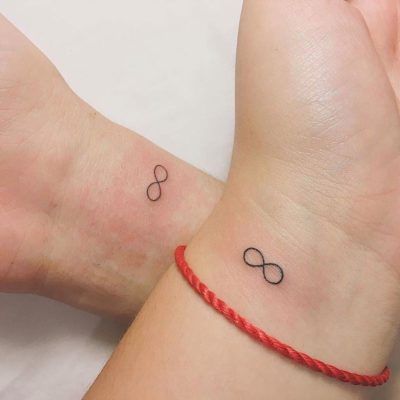 two wrist tattoos with an infinite symbol on one side and a red string around the other