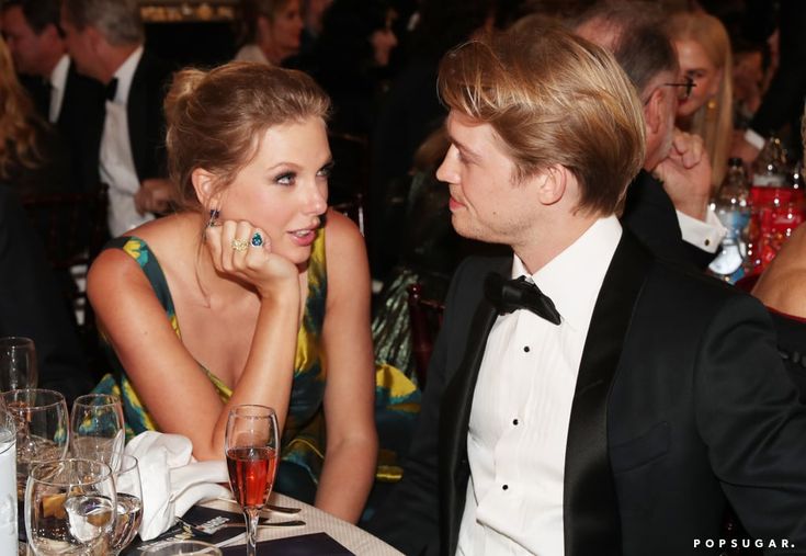 a man in a tuxedo sitting next to a woman at a table