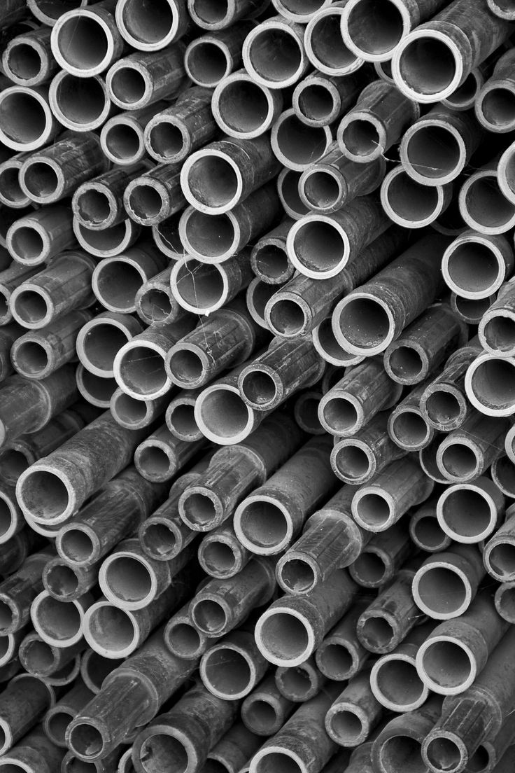 many pipes are stacked up together in black and white