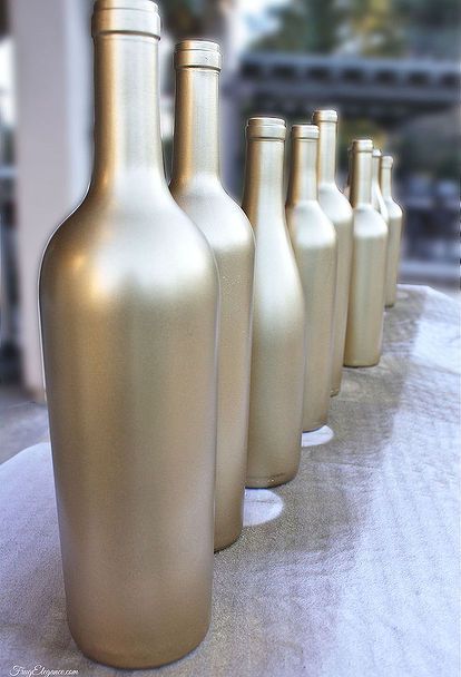 there are many gold colored bottles lined up on the table together, and one is empty