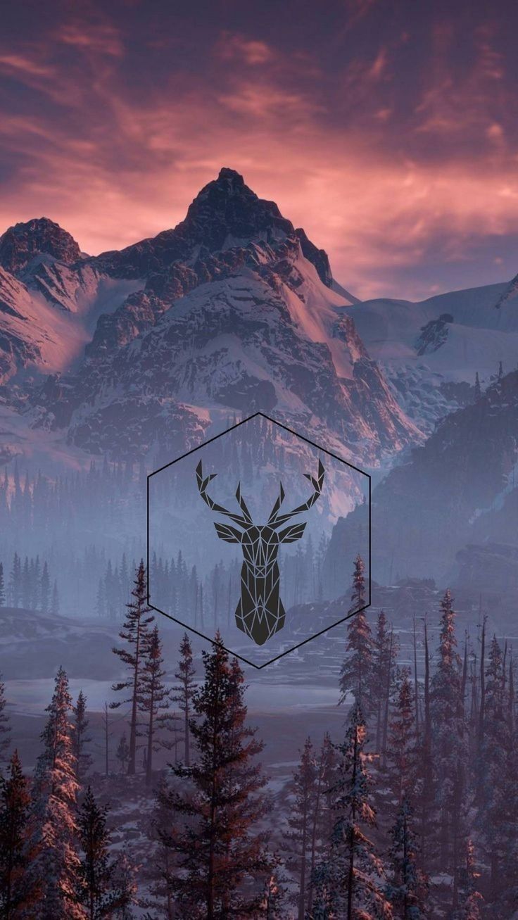 a deer head in the middle of a mountain range with trees and mountains in the background