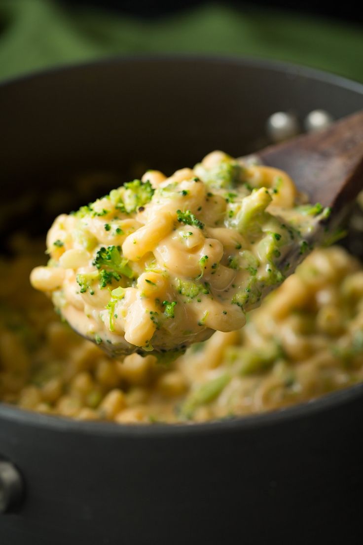 a spoon full of macaroni and cheese with broccoli