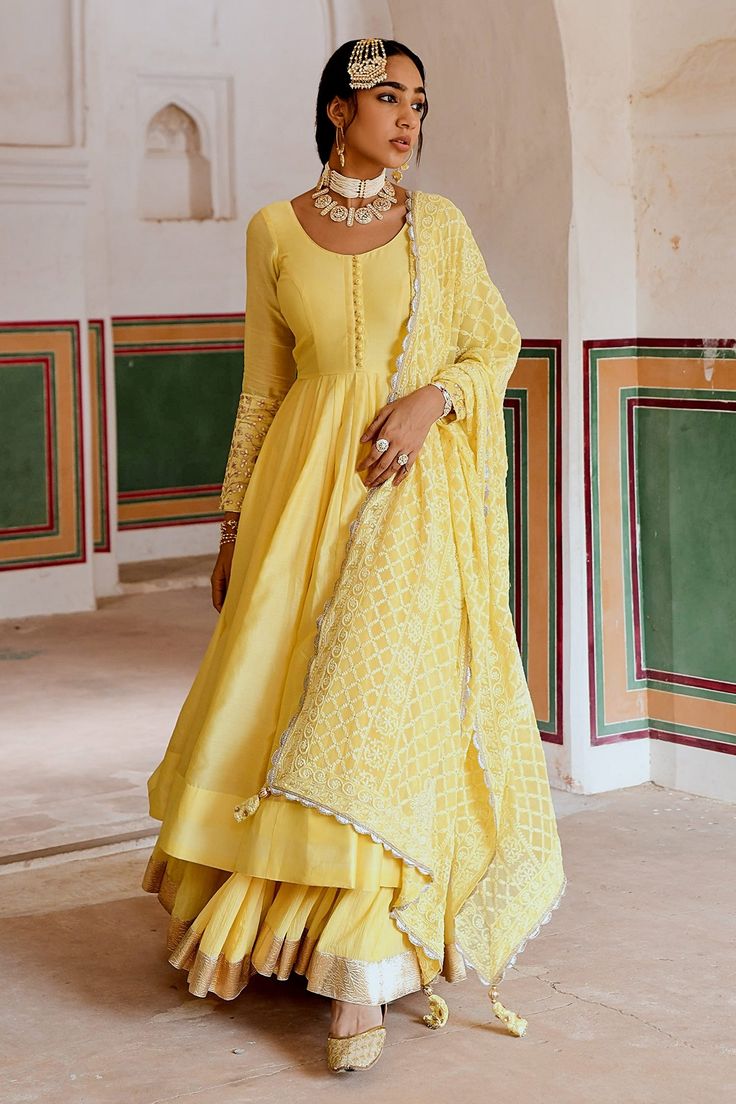 Yellow A-line flare anarkali made in chanderi base with potli buttons. Paired wit a flared skirt with a zari hemline border. Comes along with an embroidered dupatta.
Components: 3
Pattern: Placement Embroidery
Type Of Work: Zari, Thread
Neckline: Round Neck
Sleeve Type: Full Sleeves
Fabric: Anarkali: Chanderi, Skirt: Cotton Crepe, Dupatta: Embroidered Georgette
Color: Yellow
Other Details: 
Attached lining
Gota patti embroidered cuffs
Box pleated flare
Scallop laced, trellis embroidered dupatta Chanderi Anarkali, Yellow Anarkali, Placement Embroidery, Cozy Sweater Dress, Indian Bride Outfits, Embroidered Anarkali, Pakistani Wedding Outfits, Simple Pakistani Dresses, Pakistani Dress Design