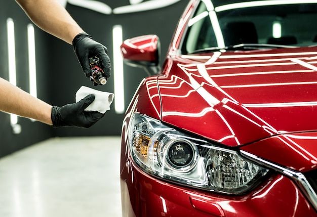 a car being waxed by a person with gloves on