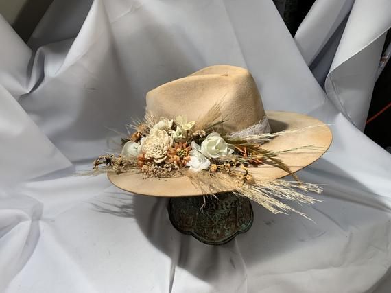 Road Warrior Custom Bridal HatFlowers can be of the color of your choosing.Available in tan or cream.4 1/2 Crown, 3 3/4 BrimCustom Color, Distressing, Band and AccessoriesAlthough each hat is unique a similar hat can be made in various sizes. Size ChartSmall - 6 7/8 Medium - 7 1/8Large - 7 3/8XL - 7 5/8XXL- 7 3/4All Sales Final Custom Brimmed Hat For Country Events, Custom Curved Brim Costume Hat For Festivals, Custom Curved Brim Festival Costume Hat, Custom Costume Hat With Curved Brim For Festivals, Custom Festival Costume Hat With Curved Brim, Custom High Crown Hats For Festivals, Custom Costume Hat With High Crown And Adjustable Fit, Custom High Crown Adjustable Costume Hats, Custom High Crown Festival Hat