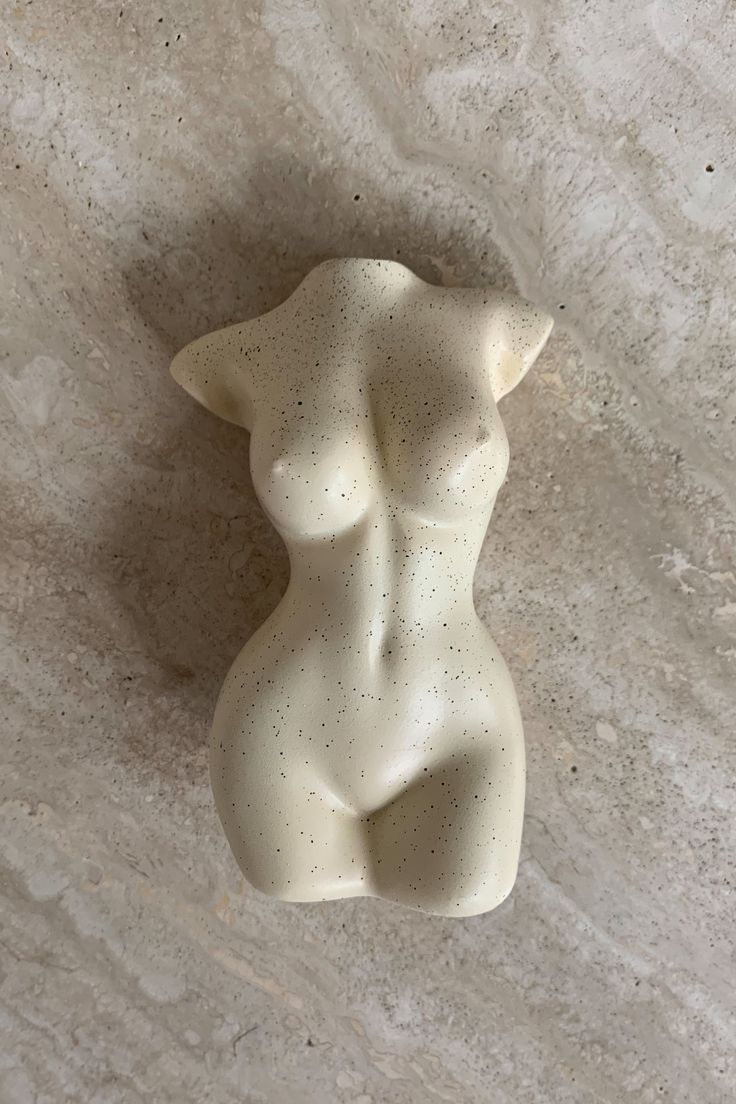 a small white sculpture sitting on top of a marble floor