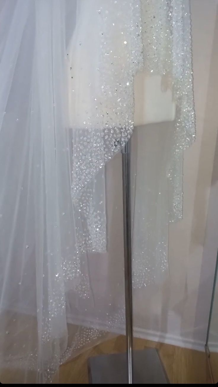 a white dress on display in front of a curtain