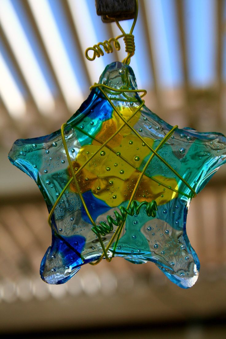 a glass star ornament hanging from a ceiling