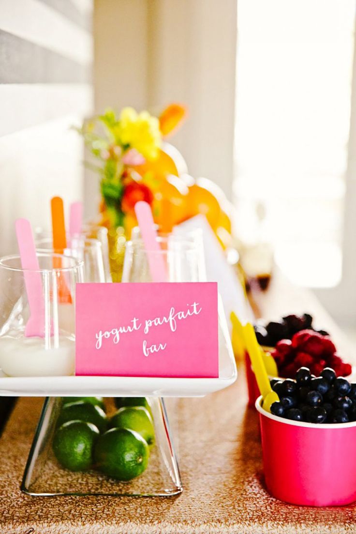 a table topped with cups filled with fruit and veggies next to a sign that says yogurt parfait fav