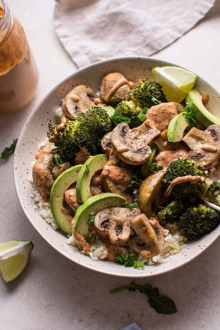 a bowl filled with chicken, broccoli and avocado on top of rice