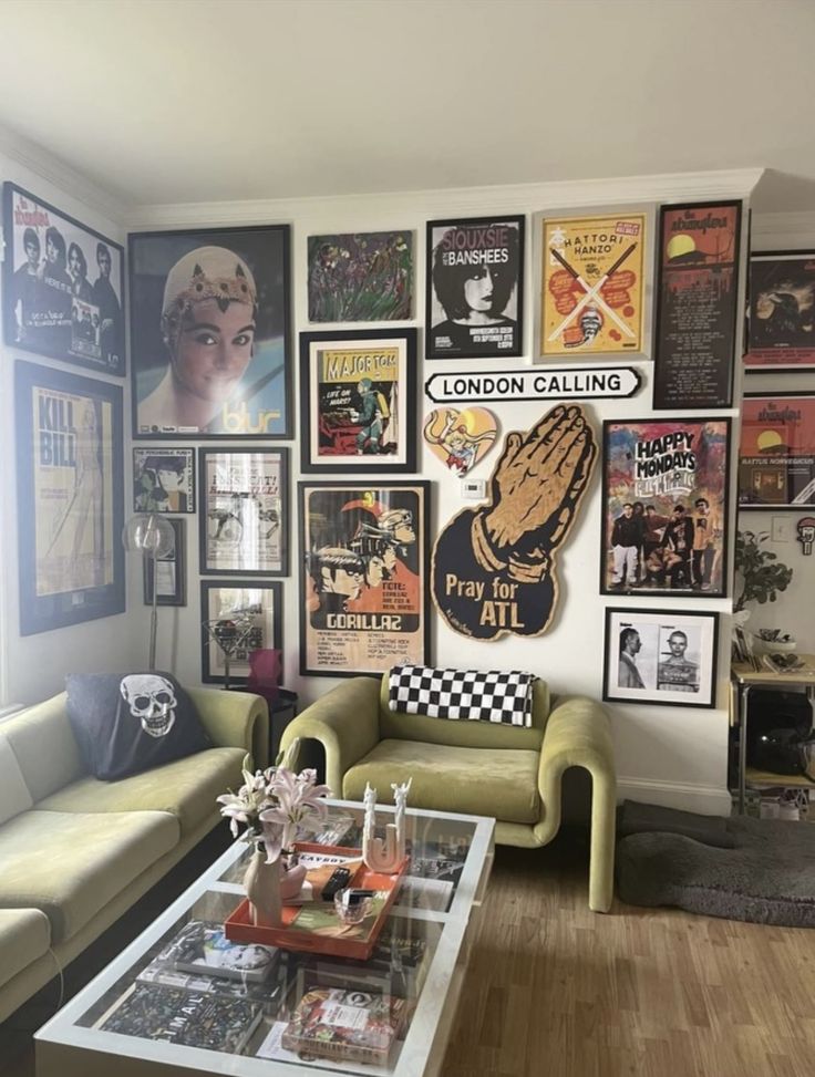 a living room filled with furniture and lots of posters on the wall above it's coffee table