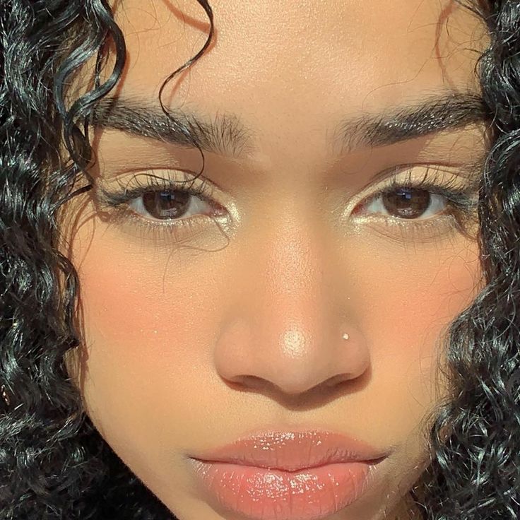 a close up of a woman's face with curly hair