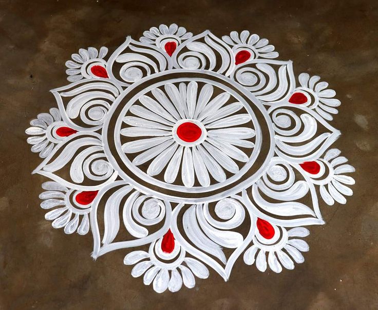 an intricate design on the ground with red and white circles around it, which is made from paper