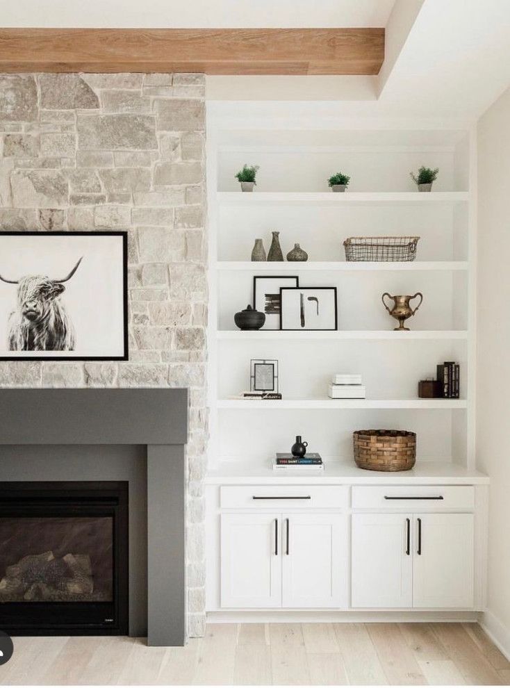 a living room filled with furniture and a fire place in front of a stone wall