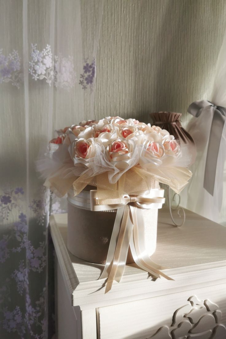 a bouquet of roses sits on top of a dresser