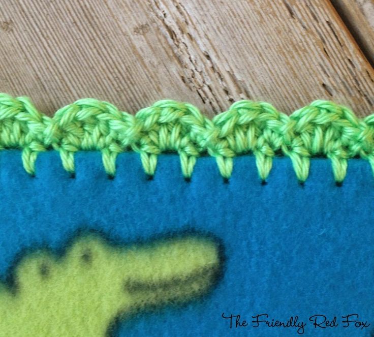 a crochet crocodile pattern is shown on the side of a piece of fabric