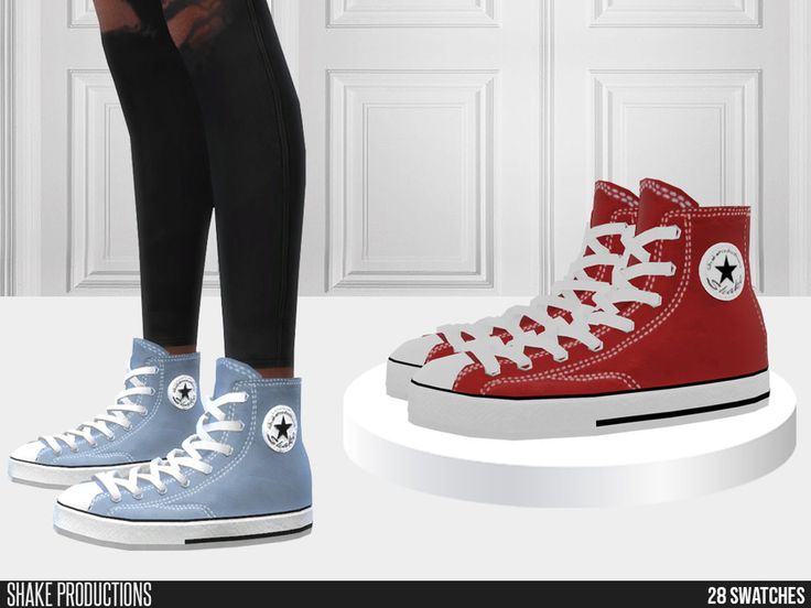 a pair of red and blue converse shoes standing next to each other in front of a white door