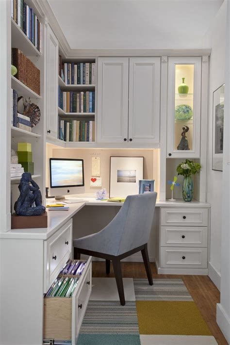 a home office with white cabinets and drawers