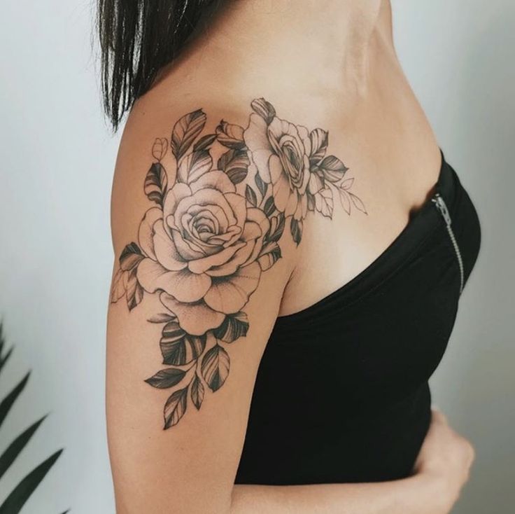 a woman with a rose tattoo on her left shoulder and right arm behind her back