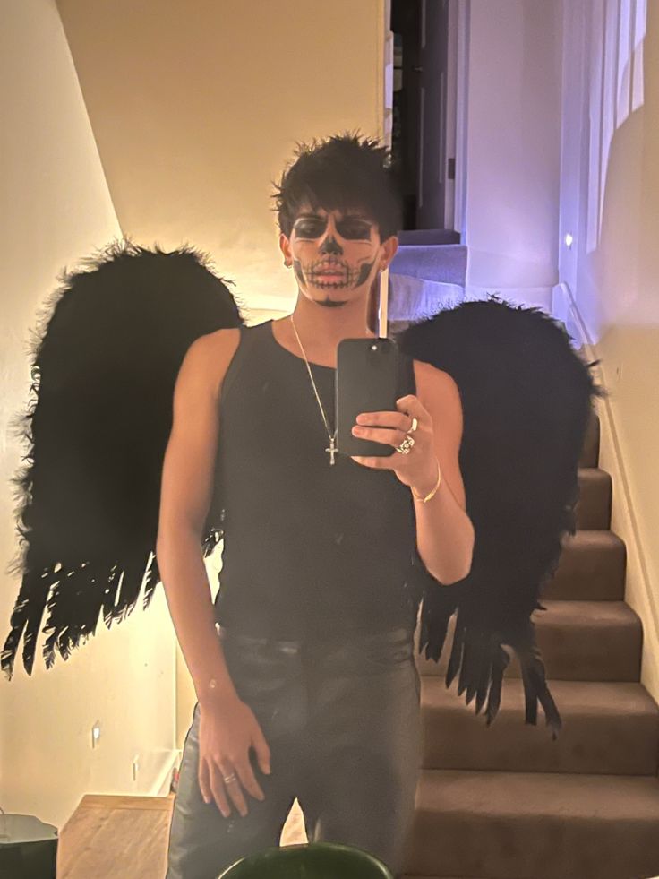 a woman in black shirt standing next to stairs with an angel wings on her head