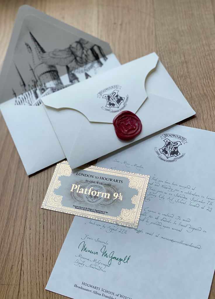 an envelope with a wax stamp on it sitting next to a letter and postcard