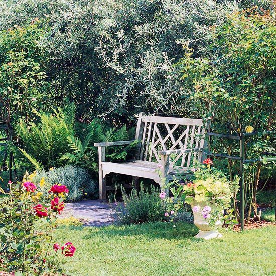 a wooden bench sitting in the middle of a garden