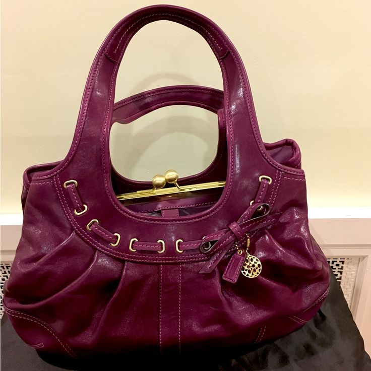 Beautiful Spacious Coach Genuine Leather Handbag With 3 Roomy Compartments. Bag Designed With A Unique Kiss Lock Completing The Middle Compartment In Color Plum. Bag In Excellent Condition And Used Only Once To A Dinner Event Then Kept Protected In Its Dust Bag (Included) And Stored In Container, In A Smoke-Free Home. Handheld Purple Leather Satchel, Coach Leather Shoulder Bag With Handles, Designer Coach Bag In Purple, Luxury Coach Satchel In Soft Leather, Coach Luxury Soft Leather Satchel, Purple Leather Handheld Shoulder Bag, Luxury Coach Soft Leather Satchel, Handheld Purple Leather Shoulder Bag, Designer Purple Bag With Gold-tone Hardware