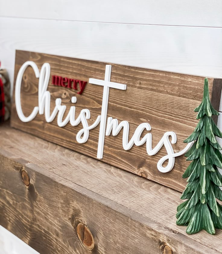 a wooden sign that says merry christmas with a pine tree