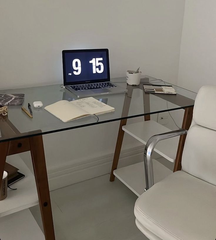 a glass desk with a laptop computer on it