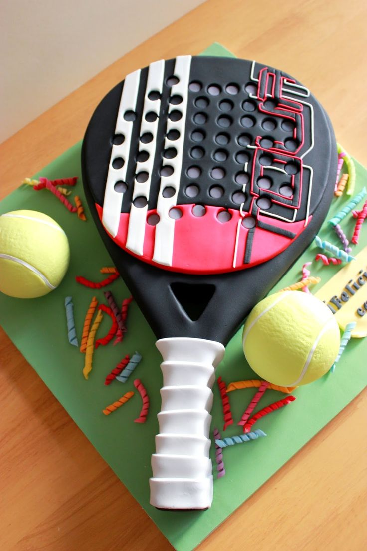 a cake made to look like a tennis racket and balls on a green board