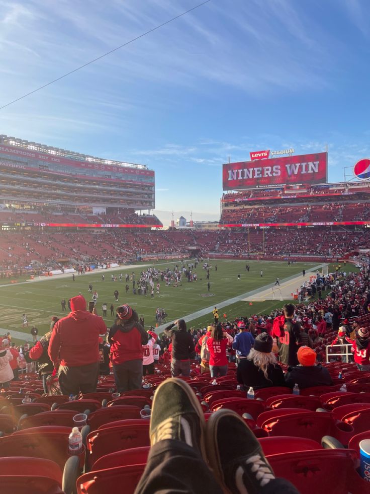 people are sitting in the stands at a football game