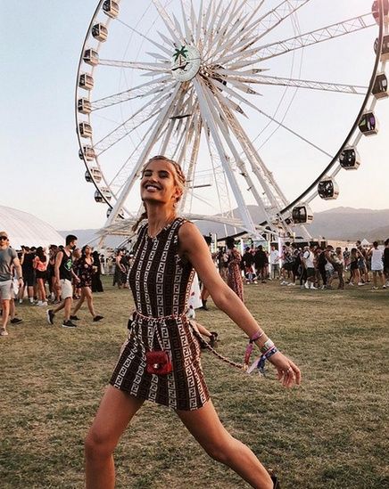 a woman standing in front of a ferris wheel with the caption's name on it