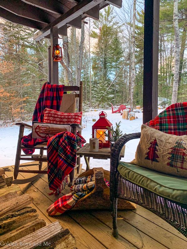 a porch covered in plaid blankets and pillows