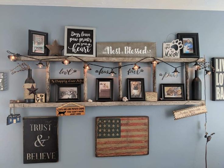 a shelf with pictures and framed photos on it in a room that has blue walls