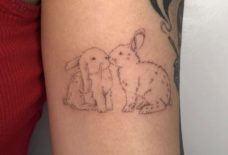 a woman's arm with two rabbits on it