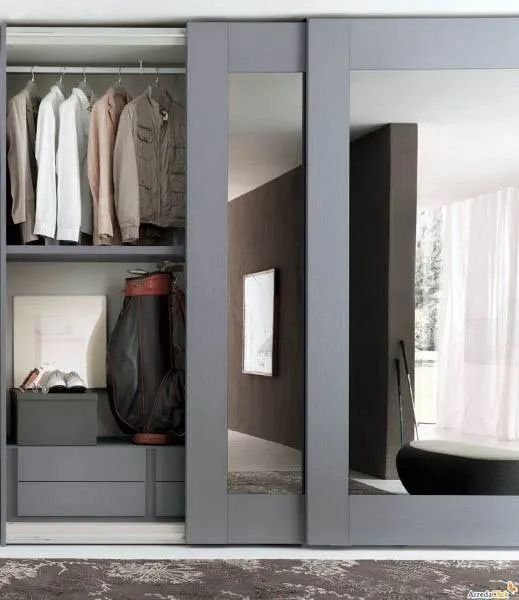 an open closet with clothes hanging on the doors