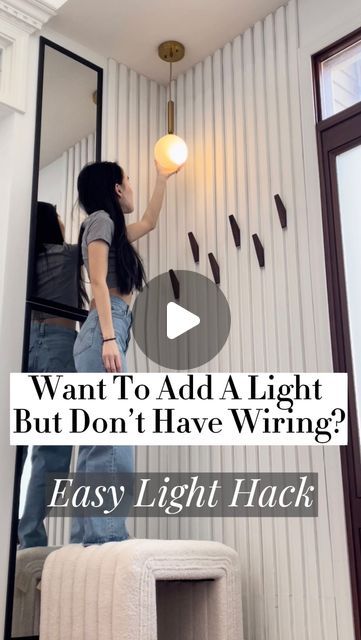 a woman standing in front of a mirror next to a wall with writing on it that says, want to add a light but don't have wiring? easy light hack