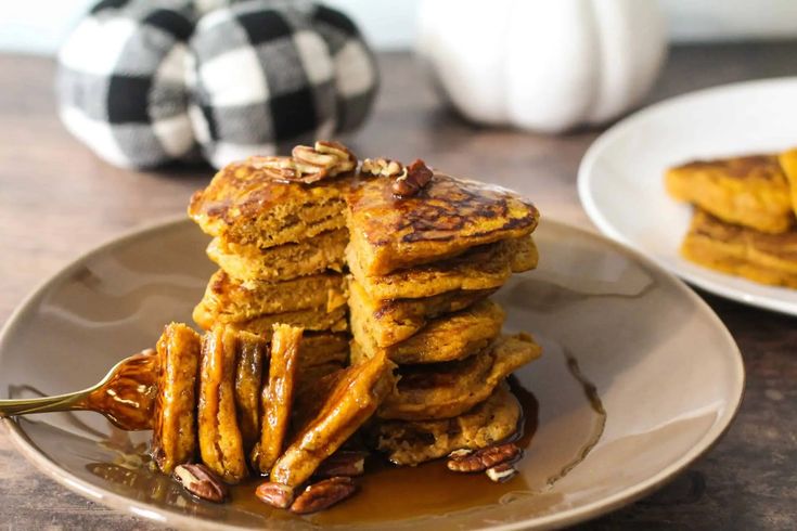 stack of pumpkin pancakes with pecans on the side