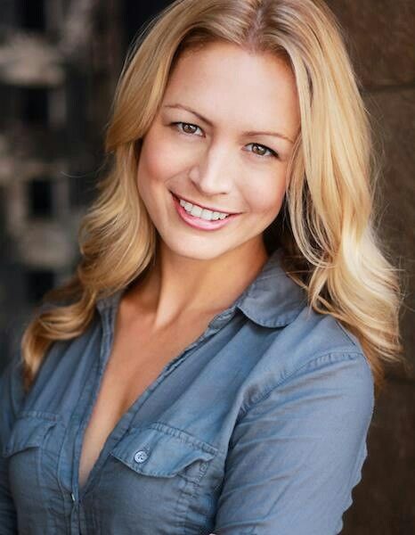 a woman with blonde hair is smiling at the camera and has her arms crossed in front of her chest