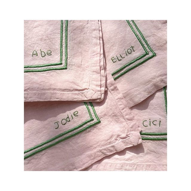 four pink napkins with green trim on each one and the words abce ellot printed on them